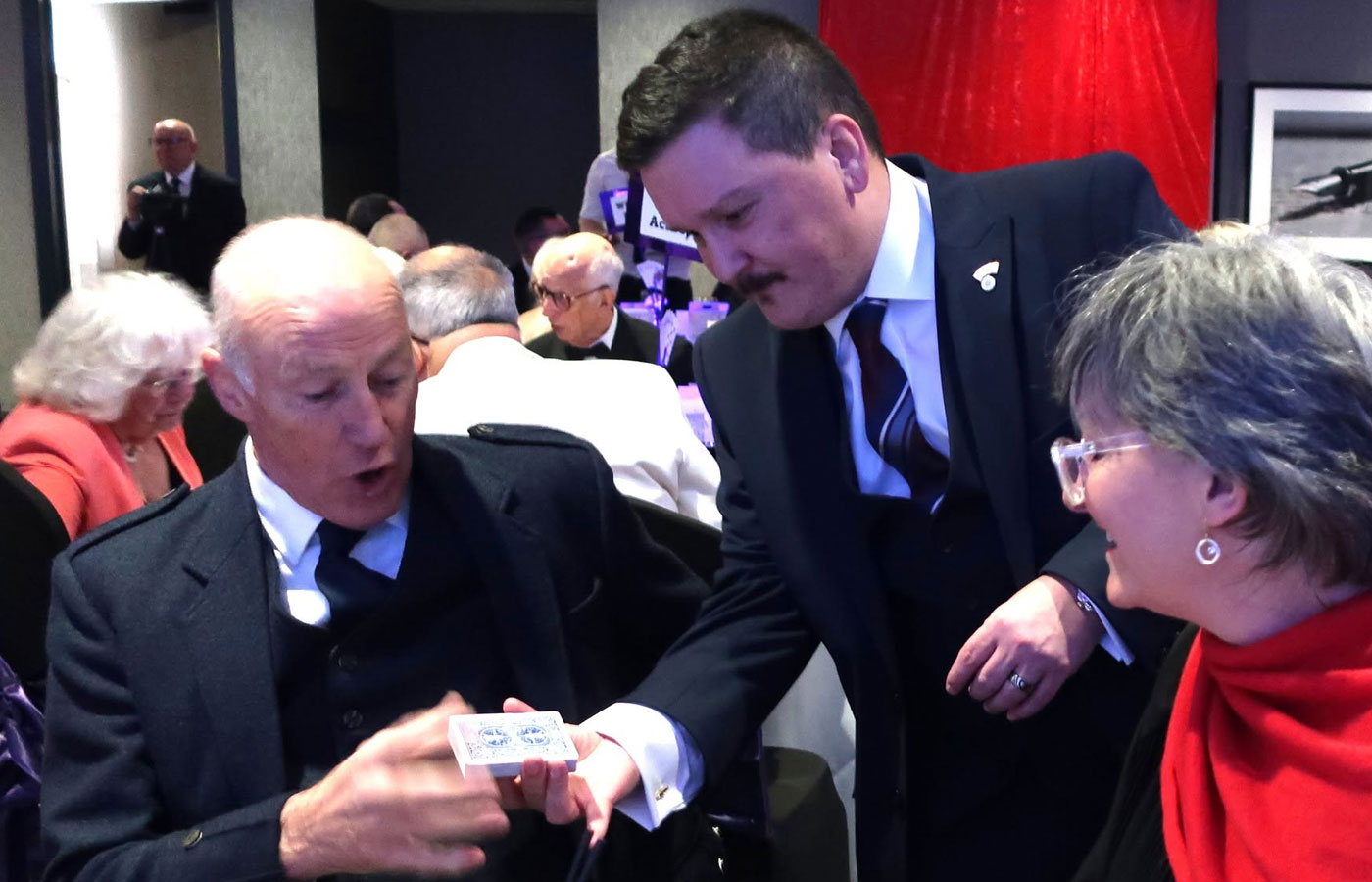 Close-up card magic being performed for dinner guests